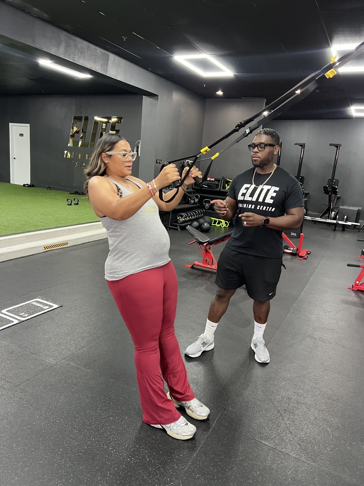 Coach Thomas Roberson working with athlete on indoor turf